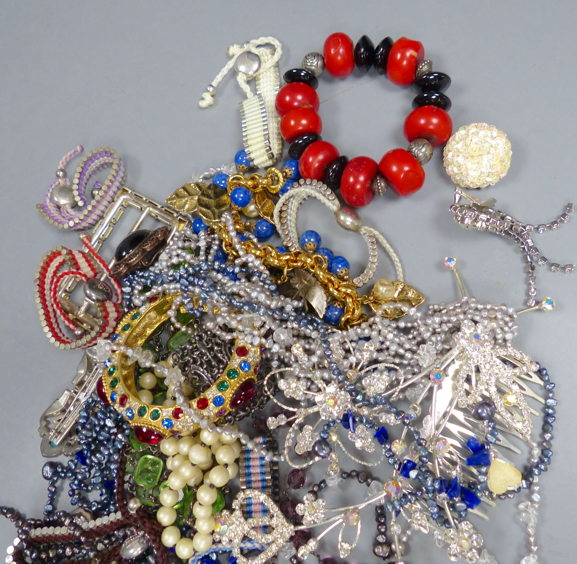 A group of assorted costume jewellery, including coloured paste necklaces.